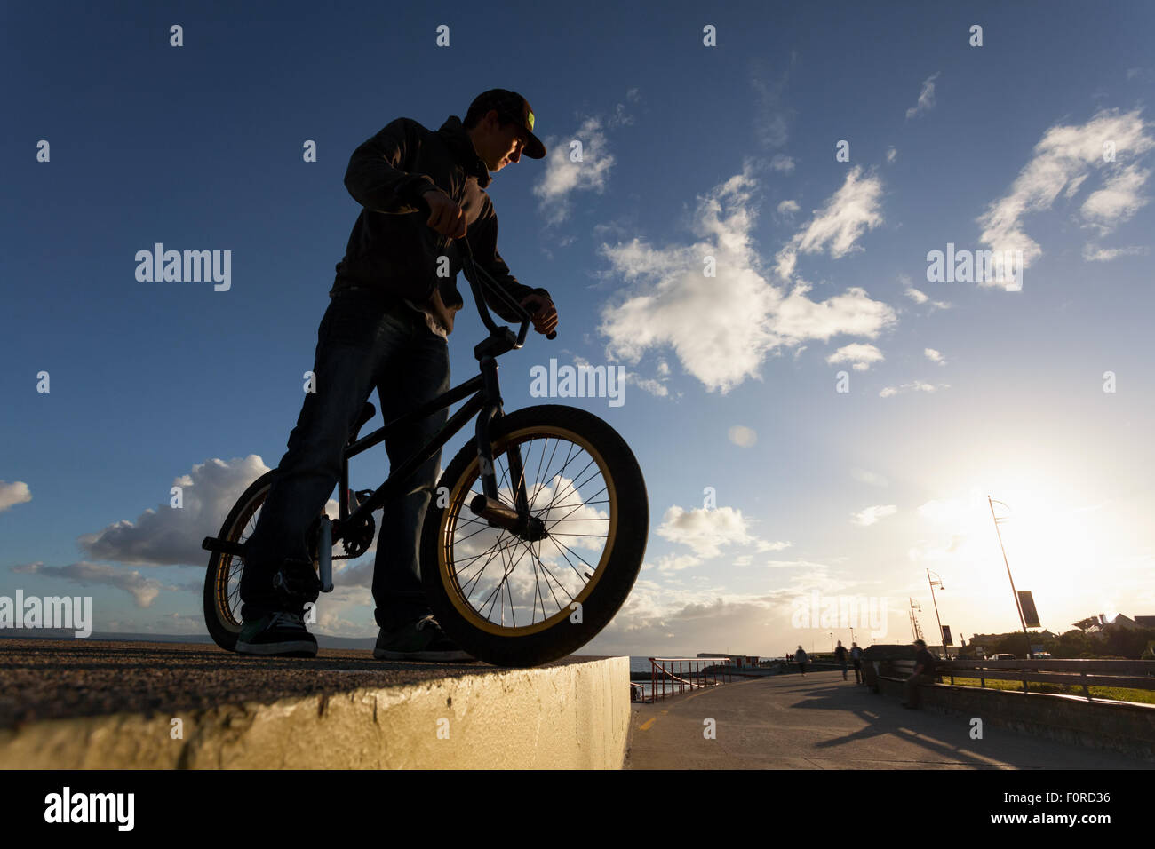 Giovane con bicicletta preparare per la BMX acrobazie in strada Foto Stock