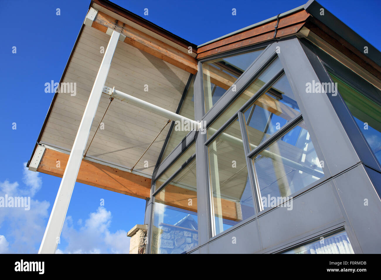 Edificio di moderna costruzione con grandi finestre di vetro contro un cielo blu Foto Stock