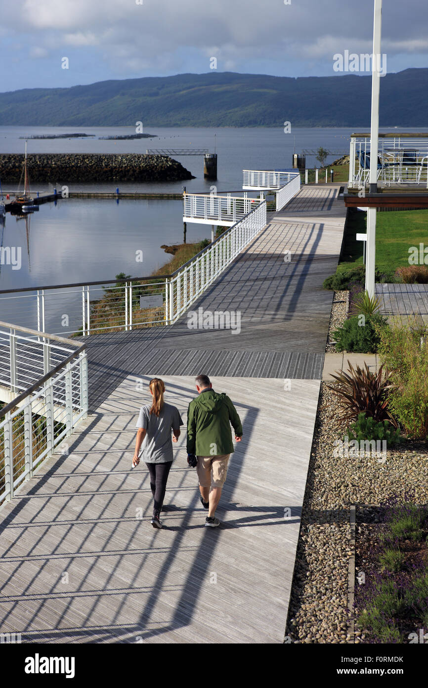 Padre e figlia camminando lungo il decking a Portavadie Marina che si siede sulle sponde del Loch Fyne in Argyll, Scozia Foto Stock