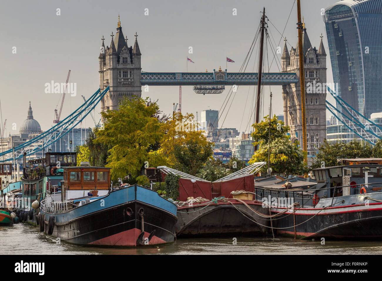 Case galleggianti e chiatte ormeggiate vicino Tower Bridge a Bermondsey con il Walkie Talkie Building, in lontananza, Londra ,UK Foto Stock