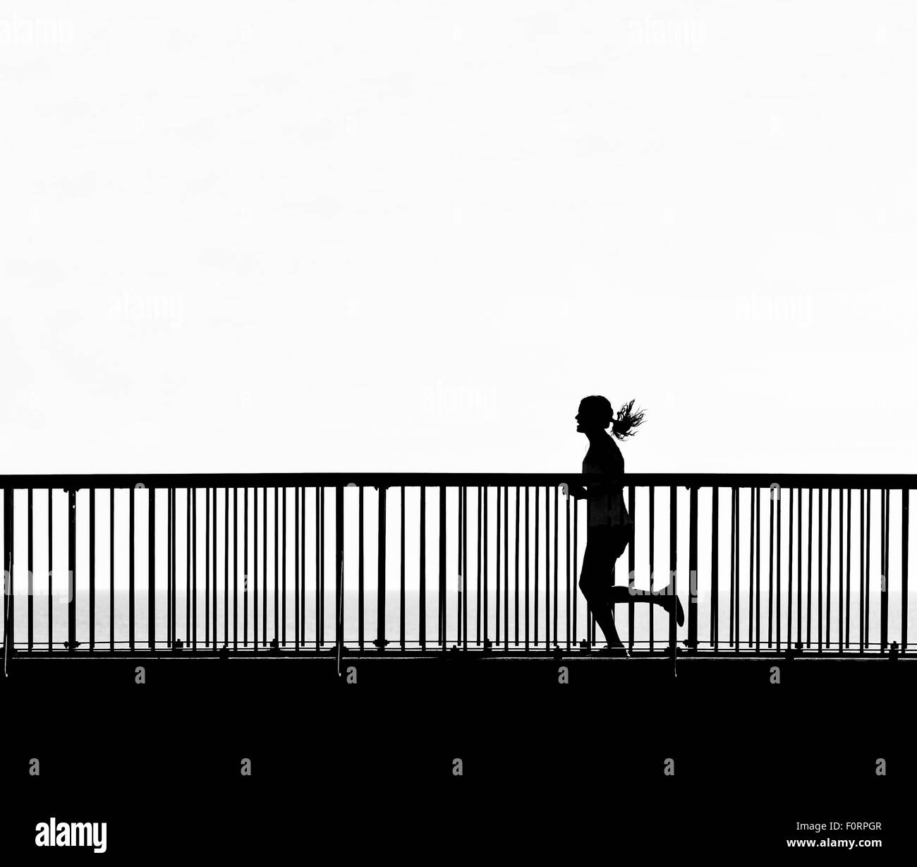 La silhouette di una donna jogging attraverso il Louisa Gap Bridge in Broadstairs Kent. Foto Stock