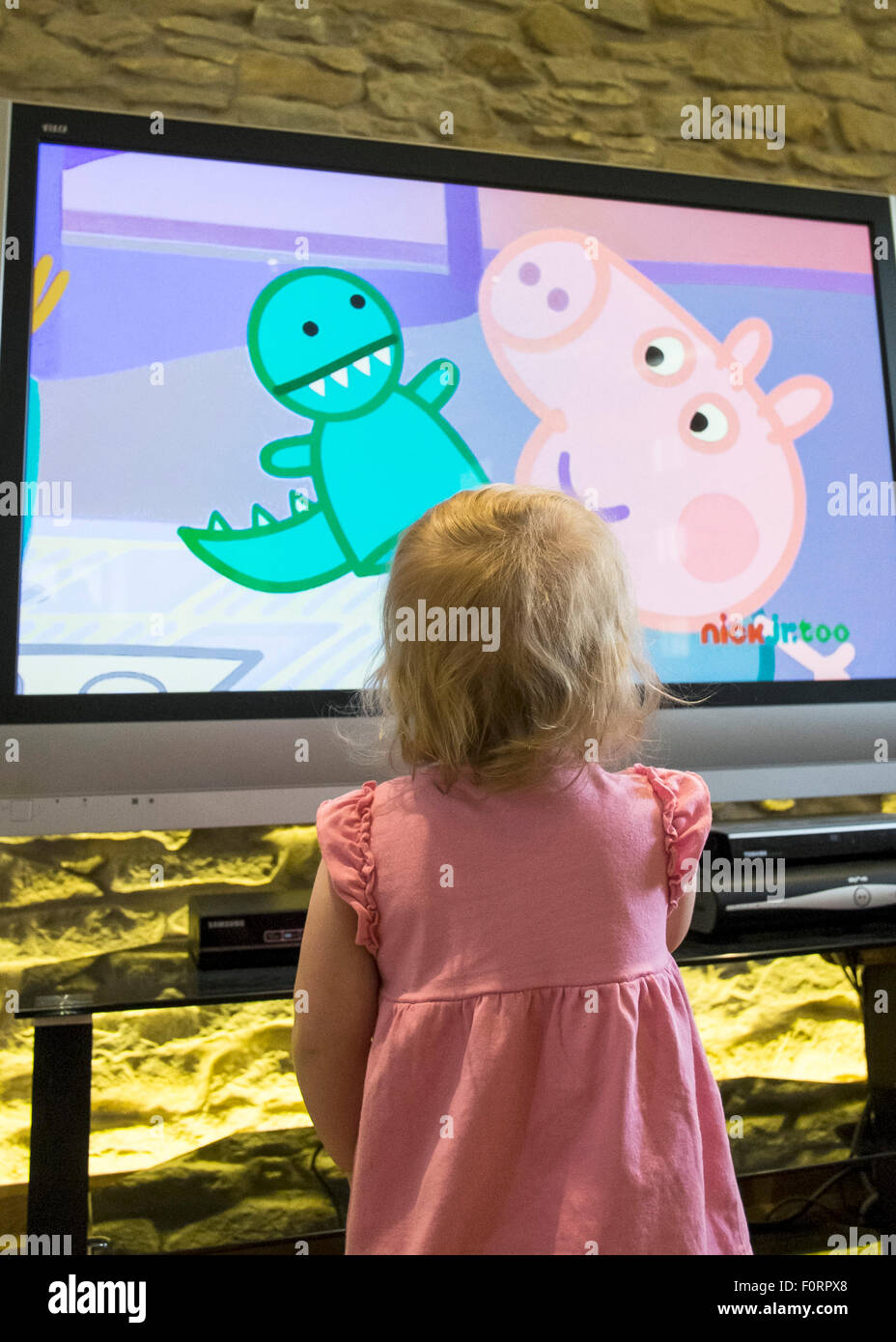 Un bambino guarda la televisione per i bambini. Foto Stock