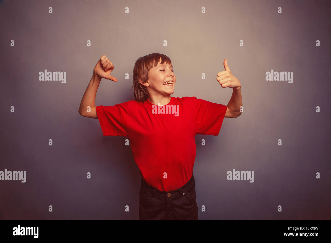 Ragazzo adolescente, dodici anni in una t-shirt rossa, cercando di th Foto Stock