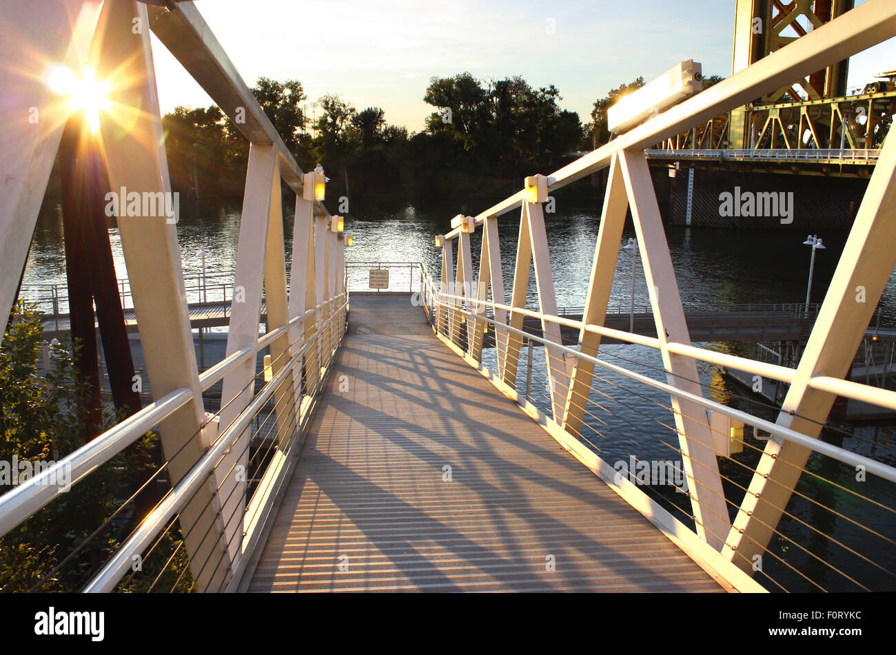 La luce del tramonto dal vecchio ponte sul fiume Foto Stock