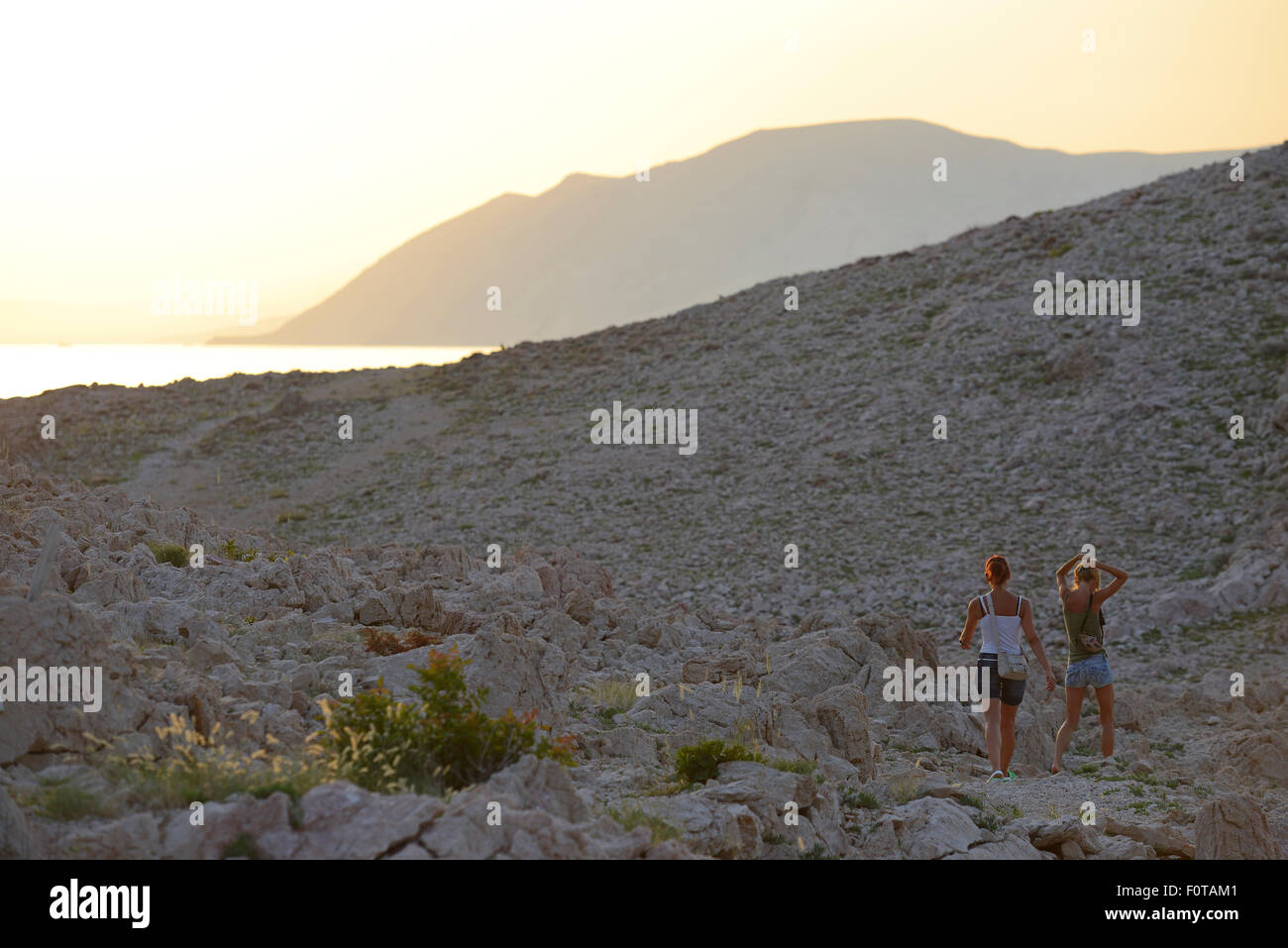 Due donne camminando lungo la costa adriatica a crepuscolo, Velebit parco naturale, Rewilding area Europa, le montagne di Velebit, Croazia Giugno 2012 Foto Stock