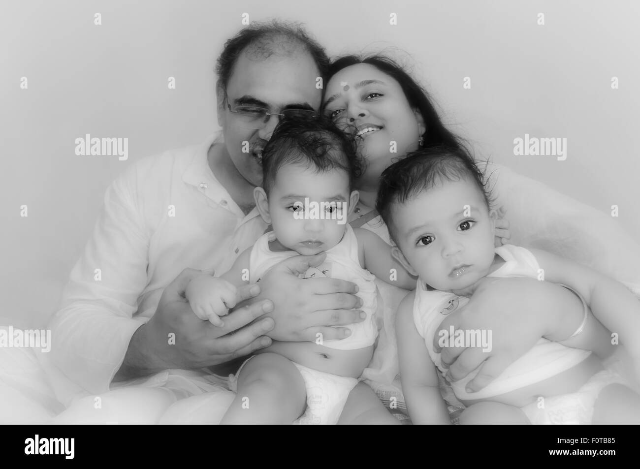 Ritratto di una famiglia felice dei genitori con twin baby boys che mostra legame, di amore, di affetto e di comunione con lo spazio di copia Foto Stock