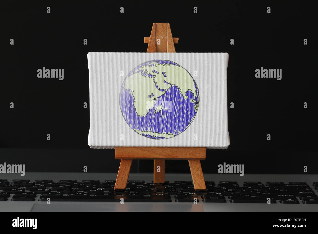 Tela vuota e il cavalletto in legno sul computer portatile come concetto Foto Stock