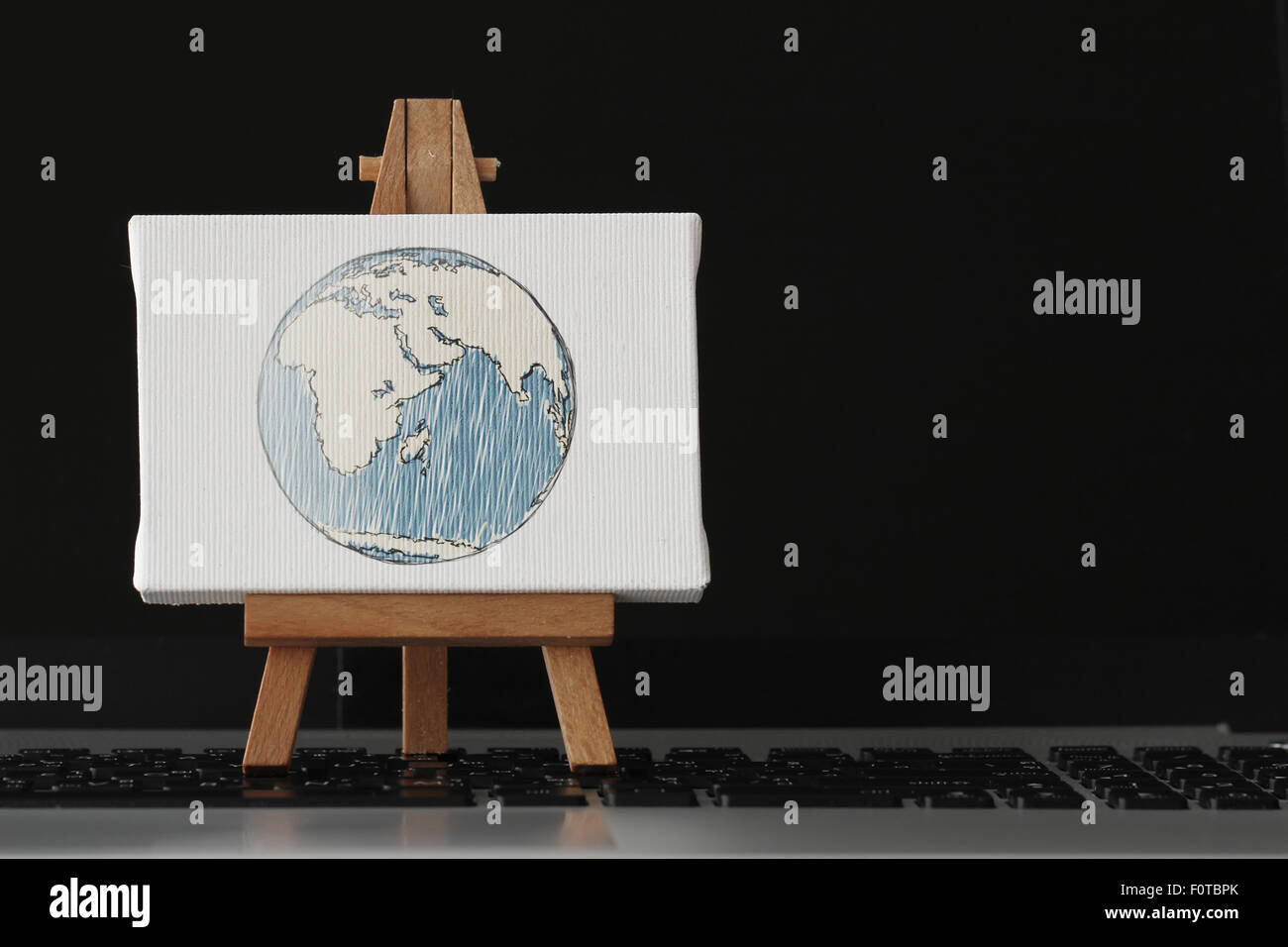 Tela vuota e il cavalletto in legno sul computer portatile come concetto Foto Stock