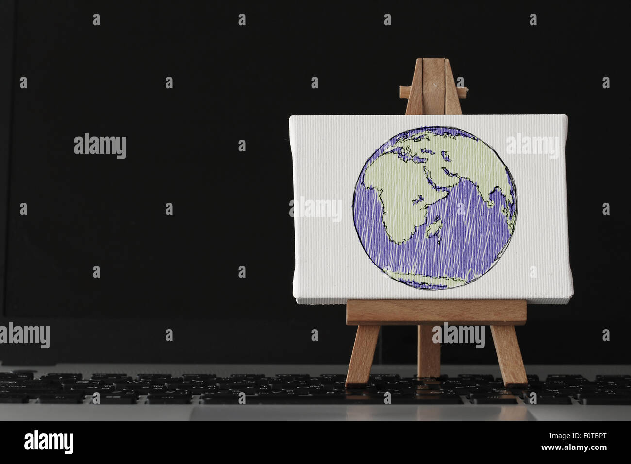 Tela vuota e il cavalletto in legno sul computer portatile come concetto Foto Stock