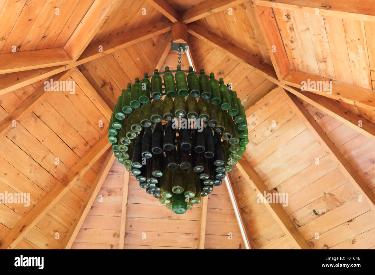 Un lampadario fatto da vecchie bottiglie in verde e blu appendere  dall'interno di un gazebo in legno Foto stock - Alamy