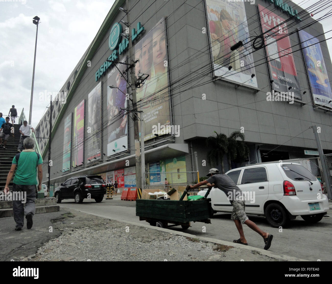 Quezon City, Filippine. 21 Ago, 2015. Un uomo filippino spinge un carrello al di fuori di un centro commerciale nella zona suburbana di Quezon City, a nord-est di Manila, Filippine, durante la XXXII anniversario dell assassinio dell ex senatore Benigno "" Ninoy Aquino Jr., padre del presidente filippino Benigno Aquino III. L'assassinio divenne la candela che infiamma una serie di proteste contro la tarda uomo forte Ferdinand Marcos. © Richard James Mendoza/Pacific Press/Alamy Live News Foto Stock