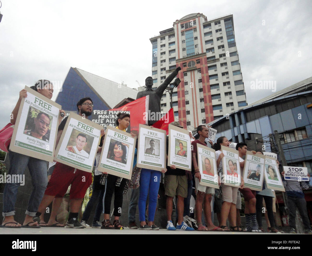 Quezon City, Filippine. 21 Ago, 2015. Gli attivisti tenere cartelli contenenti i ritratti di presunti prigionieri politici nel paese, di fronte alla statua di ex senatore Benigno "" Ninoy Aquino Jr., padre dell'attuale presidente filippino Benigno Aquino III, durante un rally nella zona suburbana di Quezon City, Filippine, al trentaduesimo anniversario dell assassinio di Ninoy Aquino da ignoti assalitori. Credito: PACIFIC PRESS/Alamy Live News Foto Stock