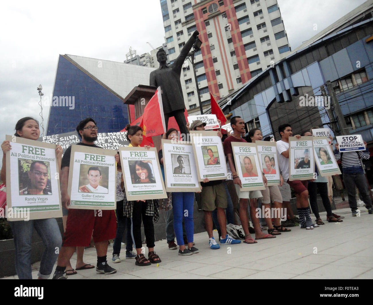 Quezon City, Filippine. 21 Ago, 2015. Gli attivisti tenere cartelli contenenti i ritratti di presunti prigionieri politici nel paese, di fronte alla statua di ex senatore Benigno "" Ninoy Aquino Jr., padre dell'attuale presidente filippino Benigno Aquino III, durante un rally nella zona suburbana di Quezon City, Filippine, al trentaduesimo anniversario dell assassinio di Ninoy Aquino da ignoti assalitori. Credito: PACIFIC PRESS/Alamy Live News Foto Stock