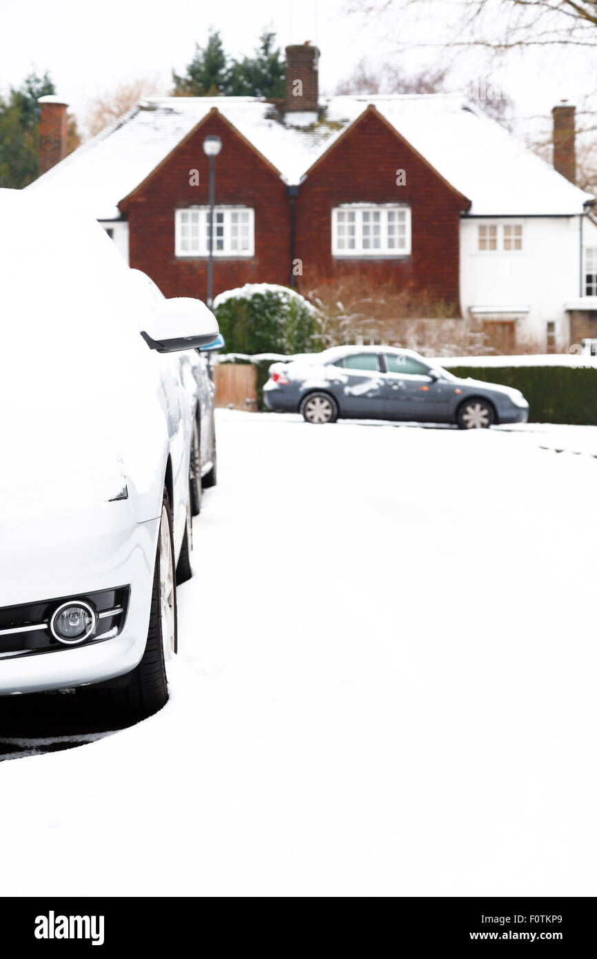 Auto parcheggiate in un villaggio Inglese in Inghilterra in inverno Foto Stock