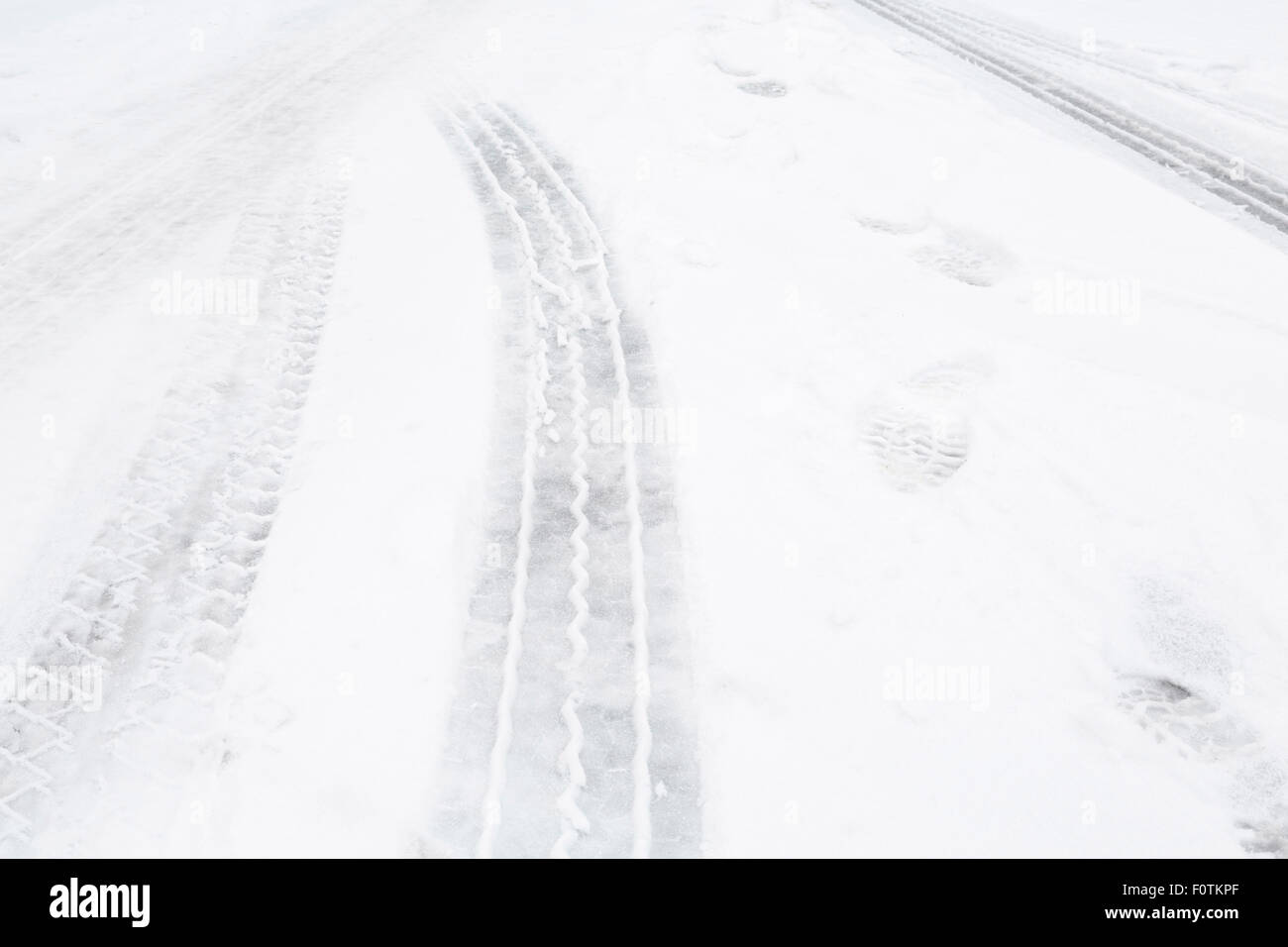 Primo piano delle tracce di pneumatici su una strada con la neve Foto Stock