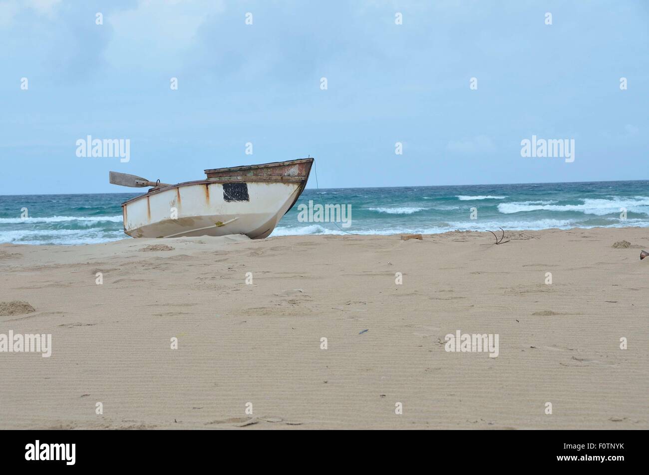 Questo vecchio, unsafe barca da pesca che giace sulla spiaggia di Inhambane, il Mozambico è in uso quotidiano. Foto Stock