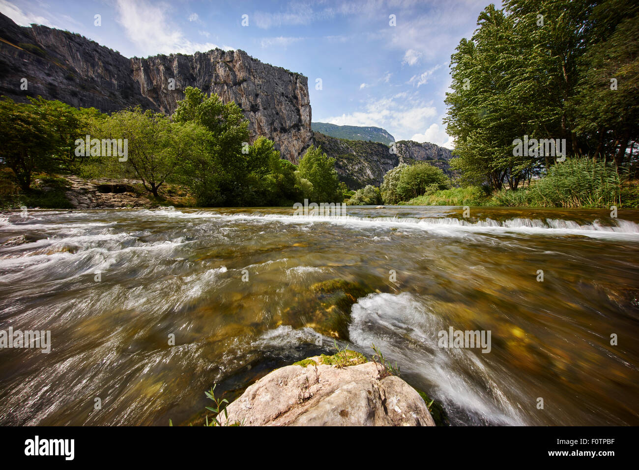 Montagna con fiume lago in una giornata di sole Foto Stock