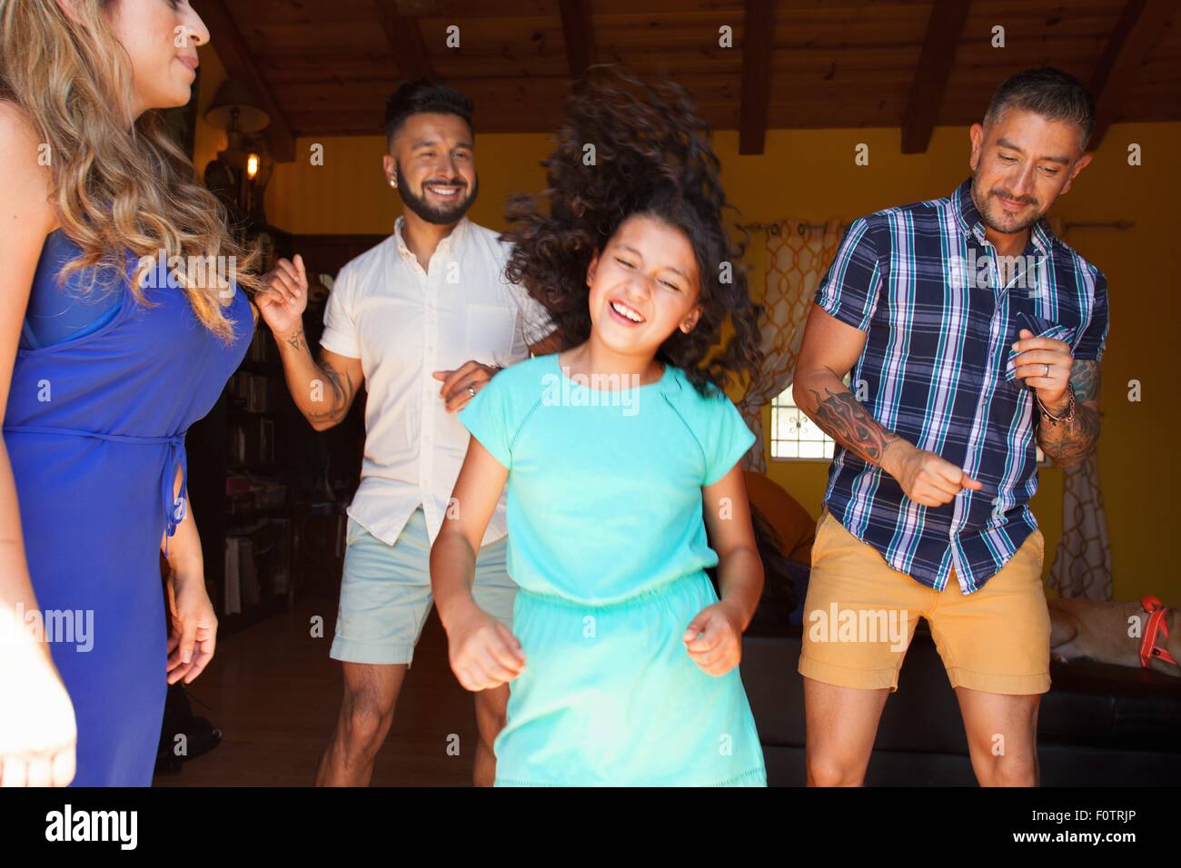 La ragazza e la famiglia in ballo nel soggiorno Foto Stock