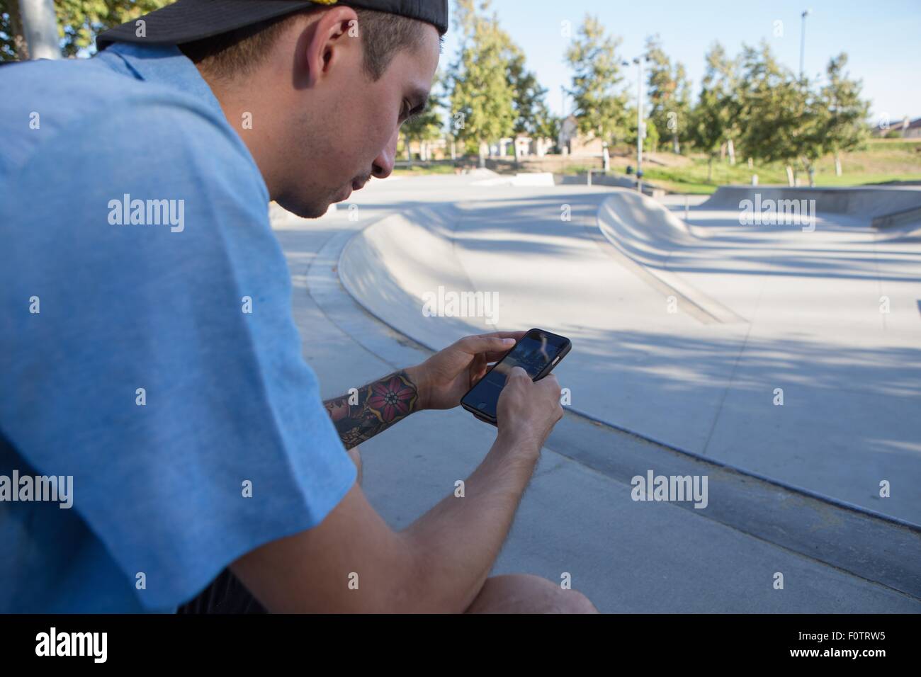 Giovane uomo utilizza lo smartphone in posizione di parcheggio Foto Stock