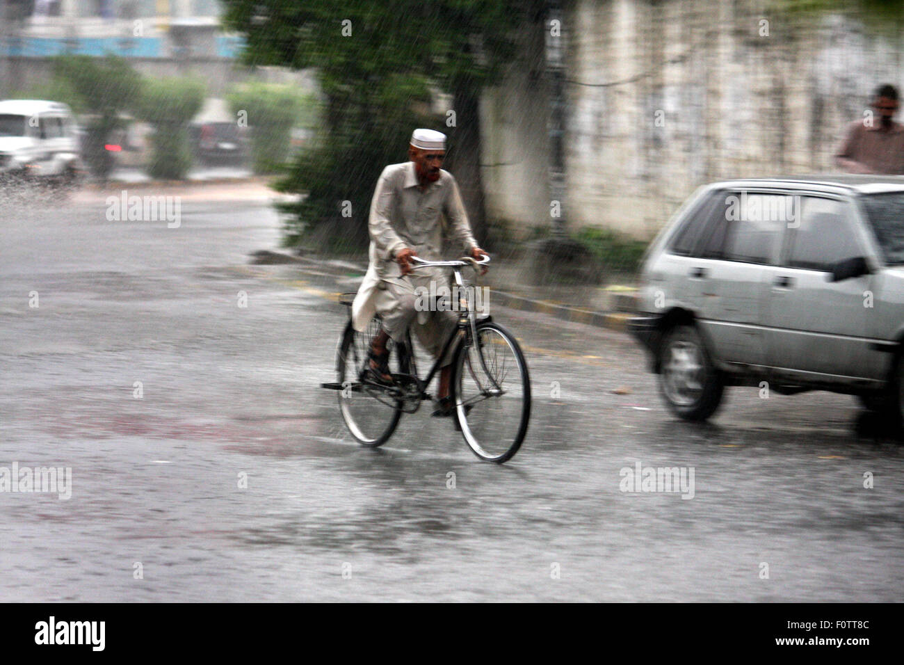 Lahore. 21 Ago, 2015. Un uomo corse bicicletta durante forti piogge monsoniche in Pakistan orientale di Lahore, Agosto 21, 2015. Credito: Jamil Ahmed/Xinhua/Alamy Live News Foto Stock