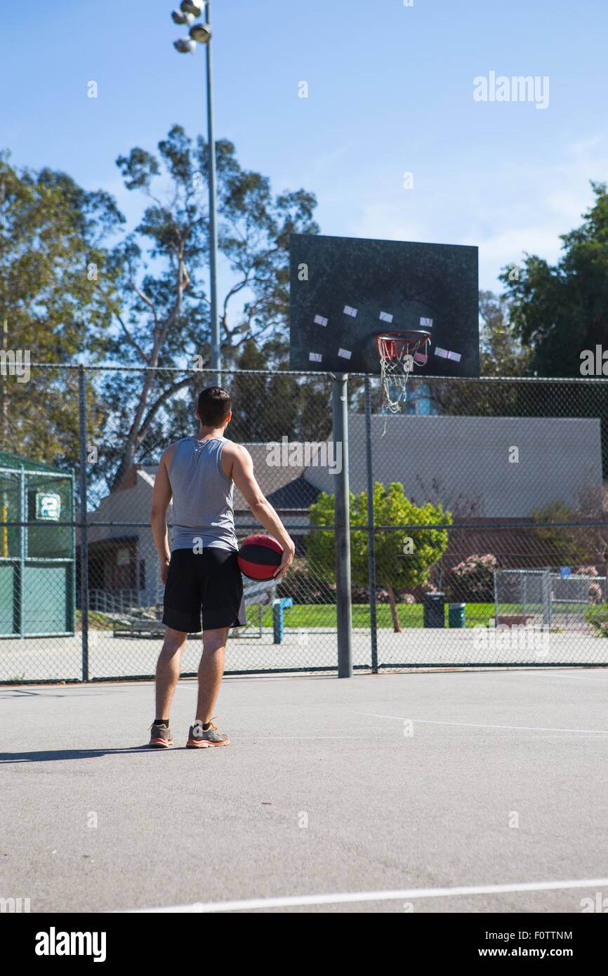 Maschio giovane giocatore di basket guardando Basketball hoop Foto Stock