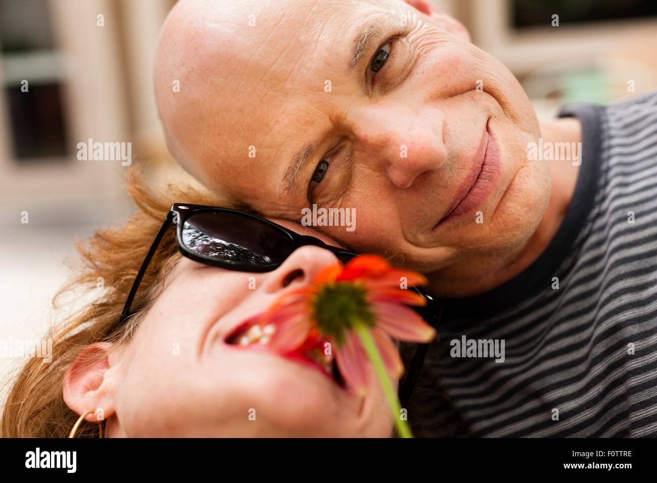 Close up ritratto della coppia sorridente con fiore rosso Foto Stock