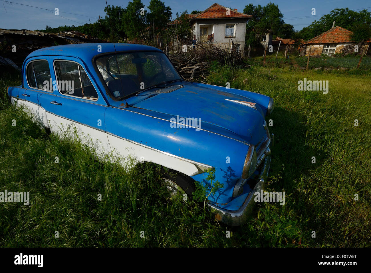 Ruggine blu auto davanti la casa, Dolni Glavanak, Orientale montagne Rodopi, Bulgaria, maggio 2013. Foto Stock