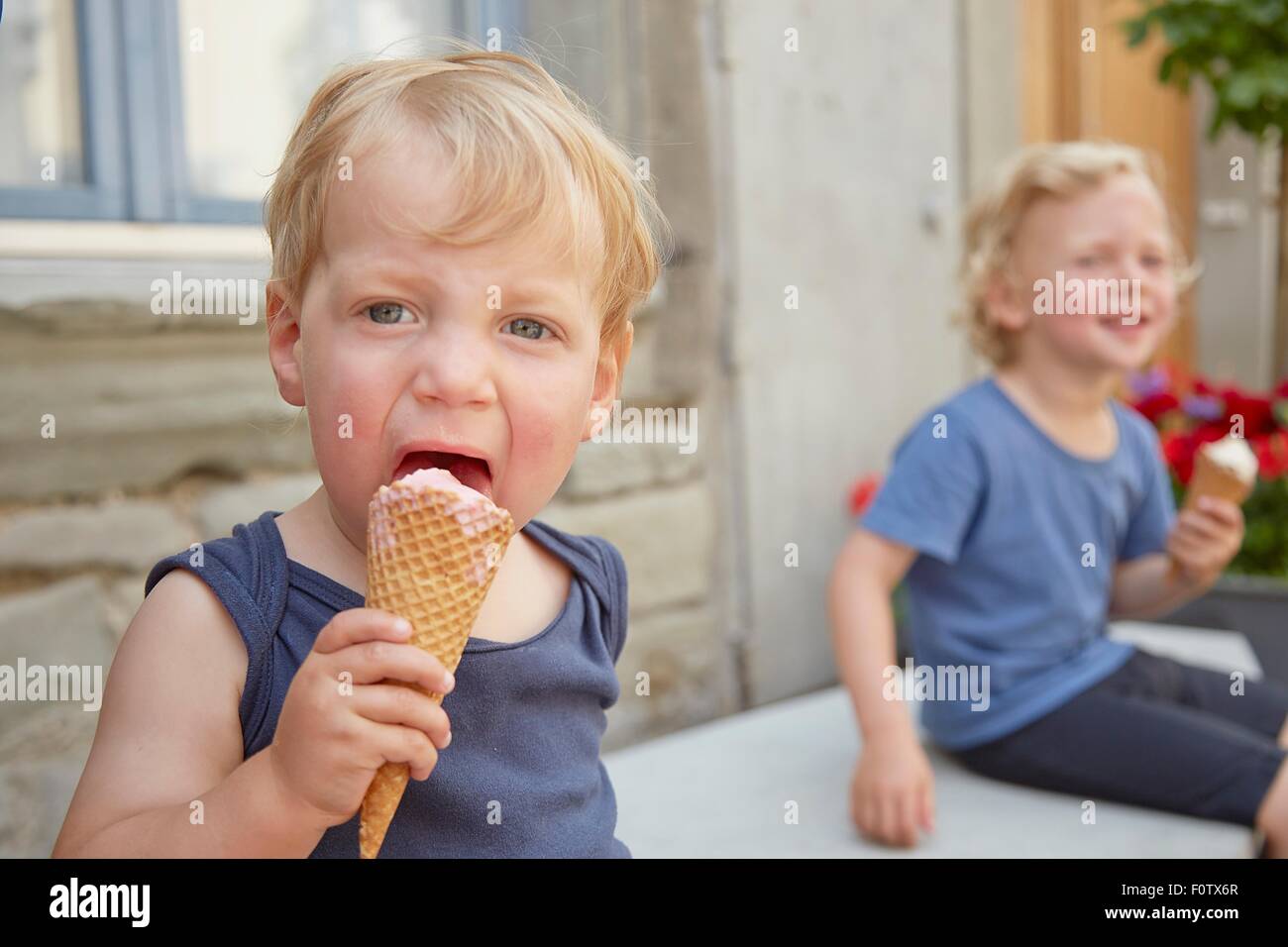 Due ragazzi seduti fuori a mangiare gelato Foto Stock