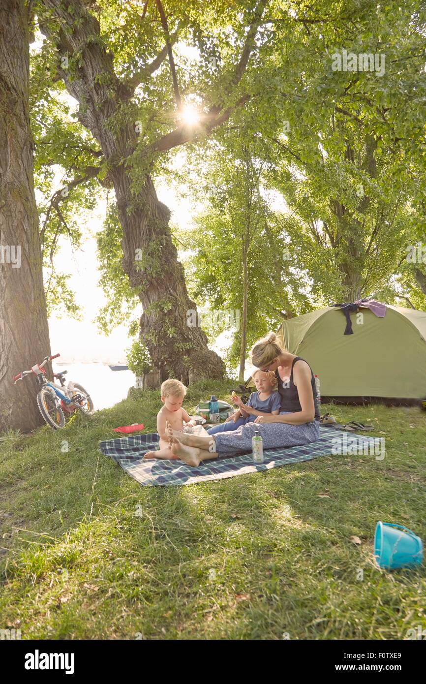Madre e figli rilassante sulla coperta picnic in ambiente rurale Foto Stock