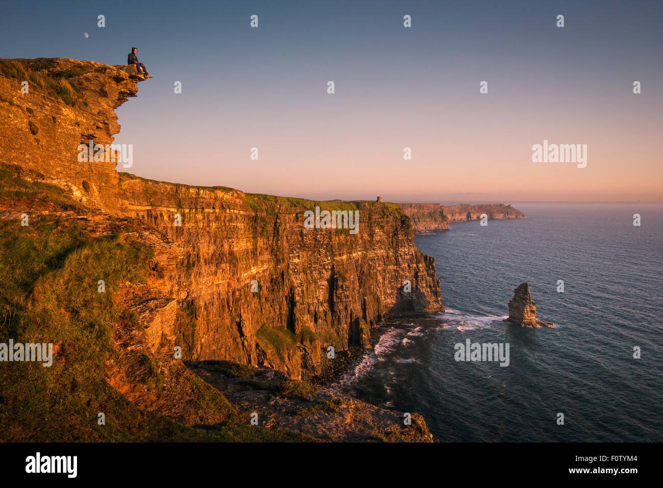 Uomo su scogliere di Moher, Liscannor, Irlanda Foto Stock