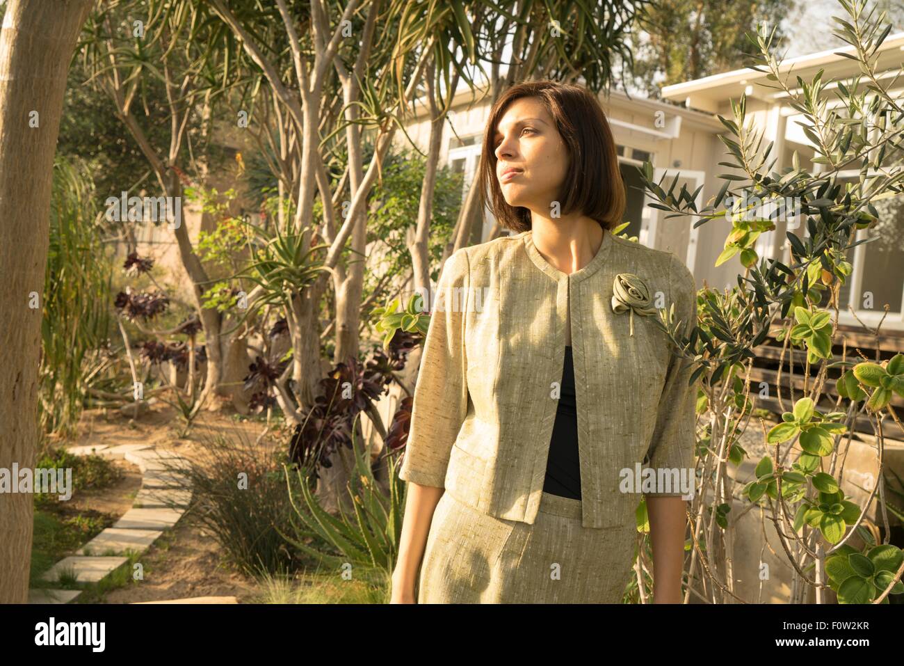 Metà donna adulta che guarda lontano dal giardino Foto Stock