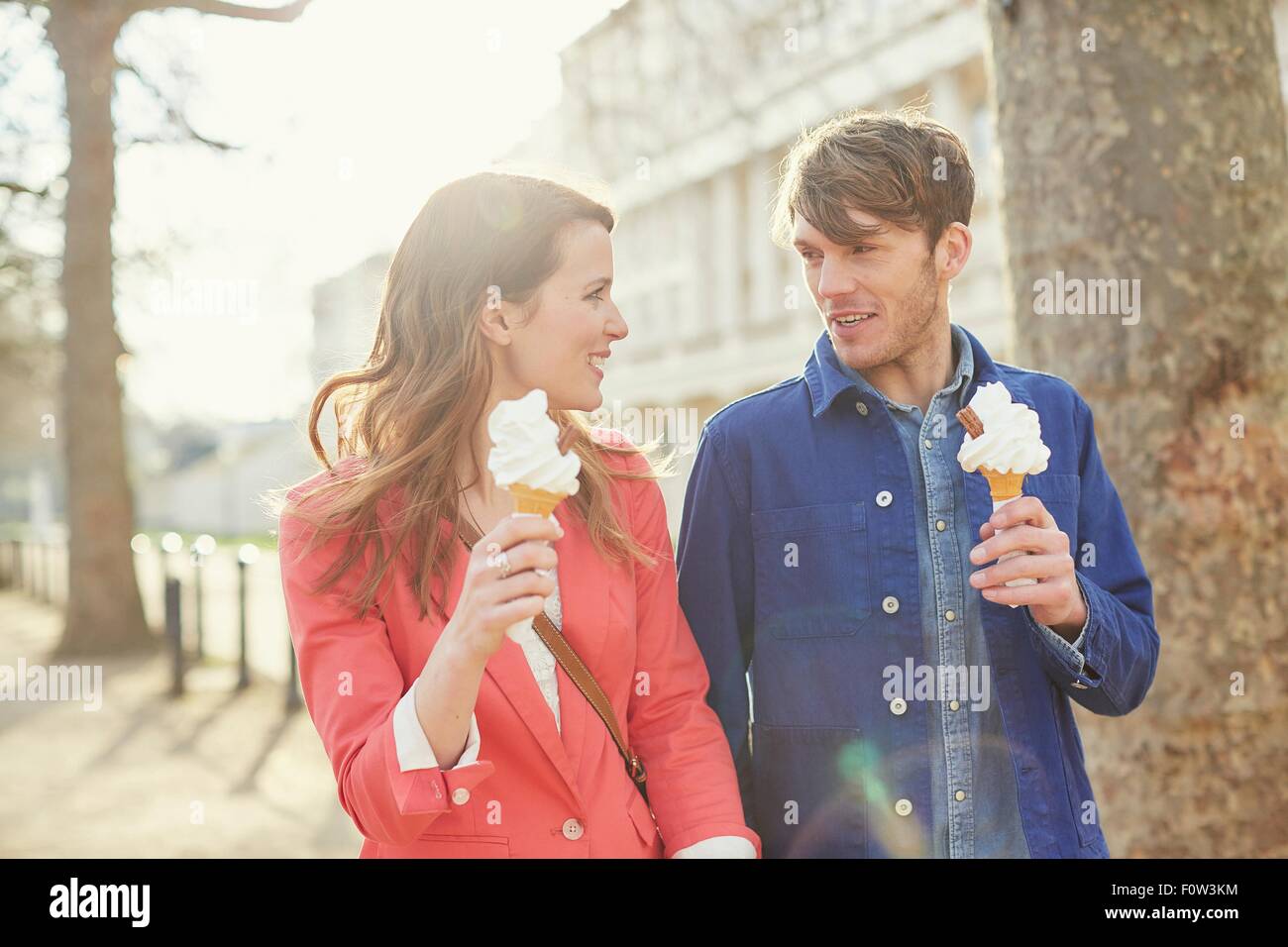 Paio mangiare coni gelato mentre passeggiando lungo Street, Londra, Regno Unito Foto Stock