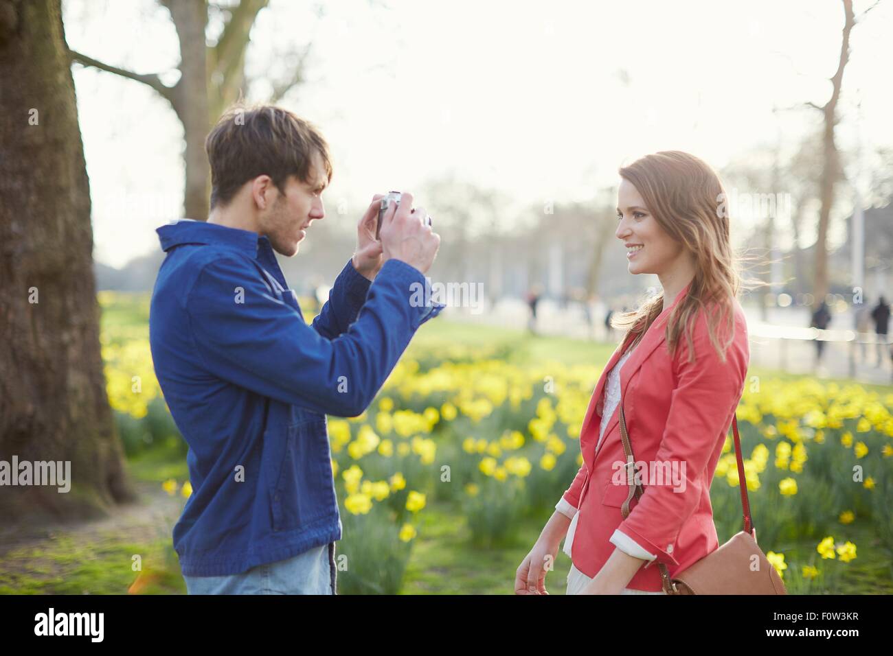 Metà uomo adulto fotografare la ragazza in park, london, Regno Unito Foto Stock
