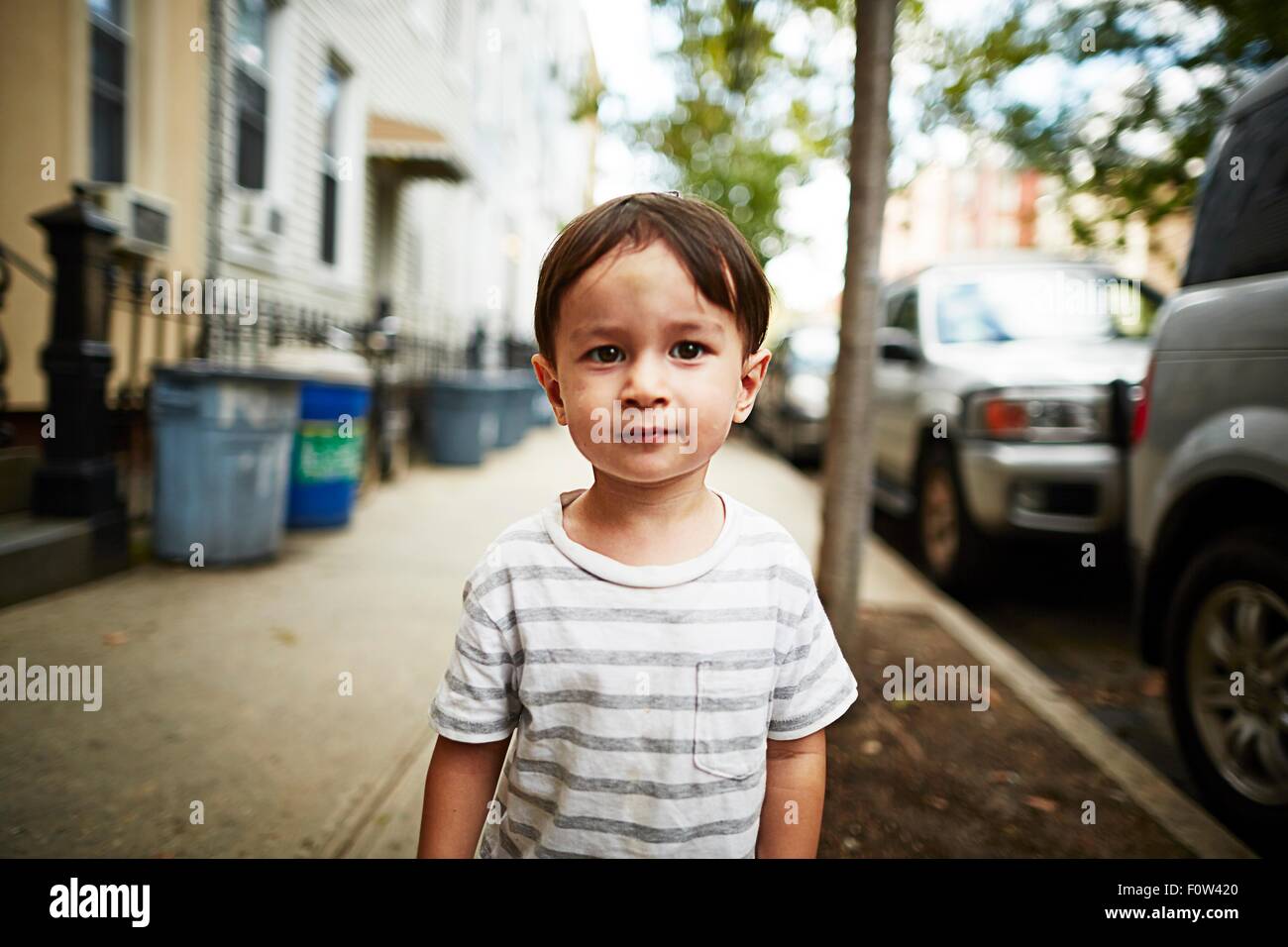 Ragazzo in piedi sul marciapiede Foto Stock