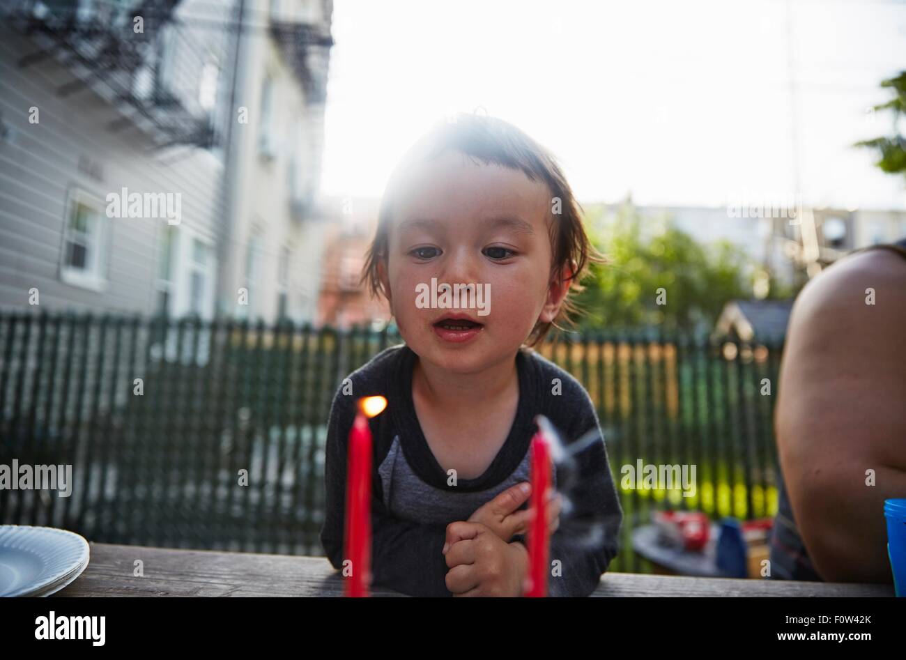 Ragazzo che guarda alla candela accesa sul tavolo da pranzo Foto Stock