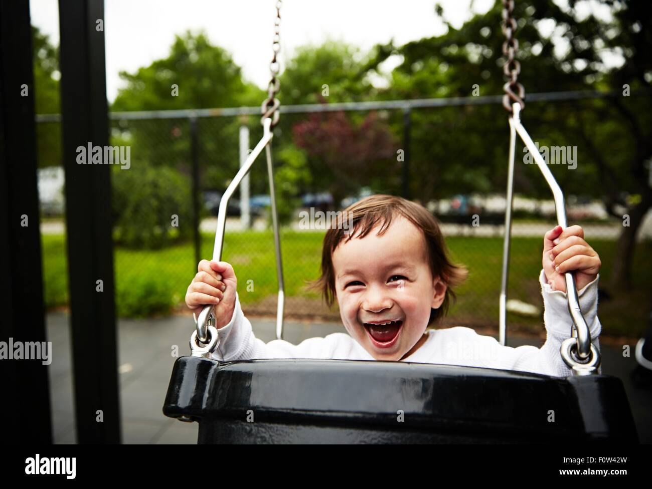 Ragazzo giocando su swing Foto Stock