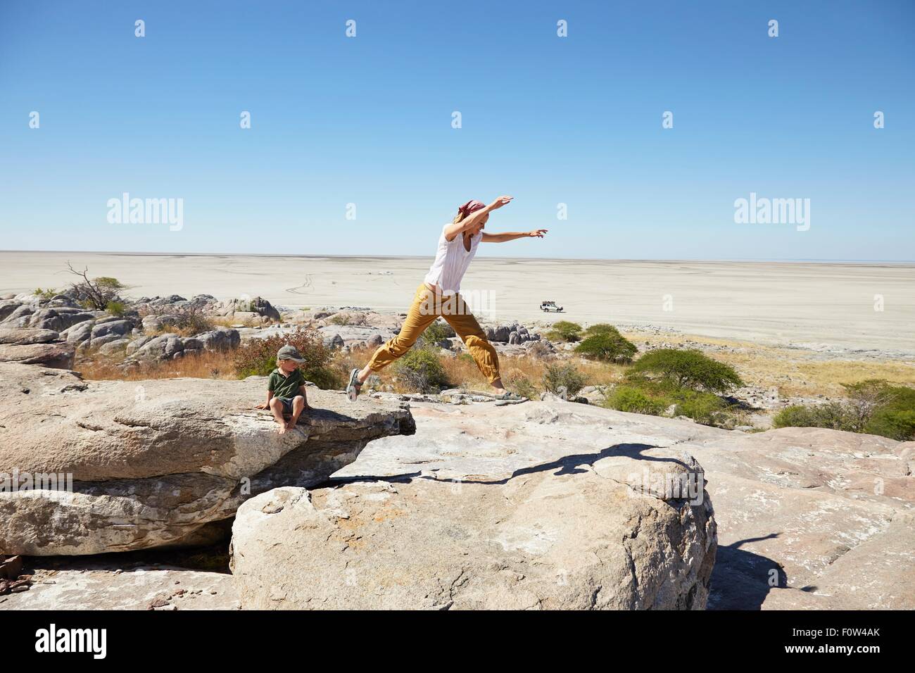 Madre e figlio giocando sulla roccia, Kubu Island, Makgadikgadi Pan, Botswana, Africa Foto Stock