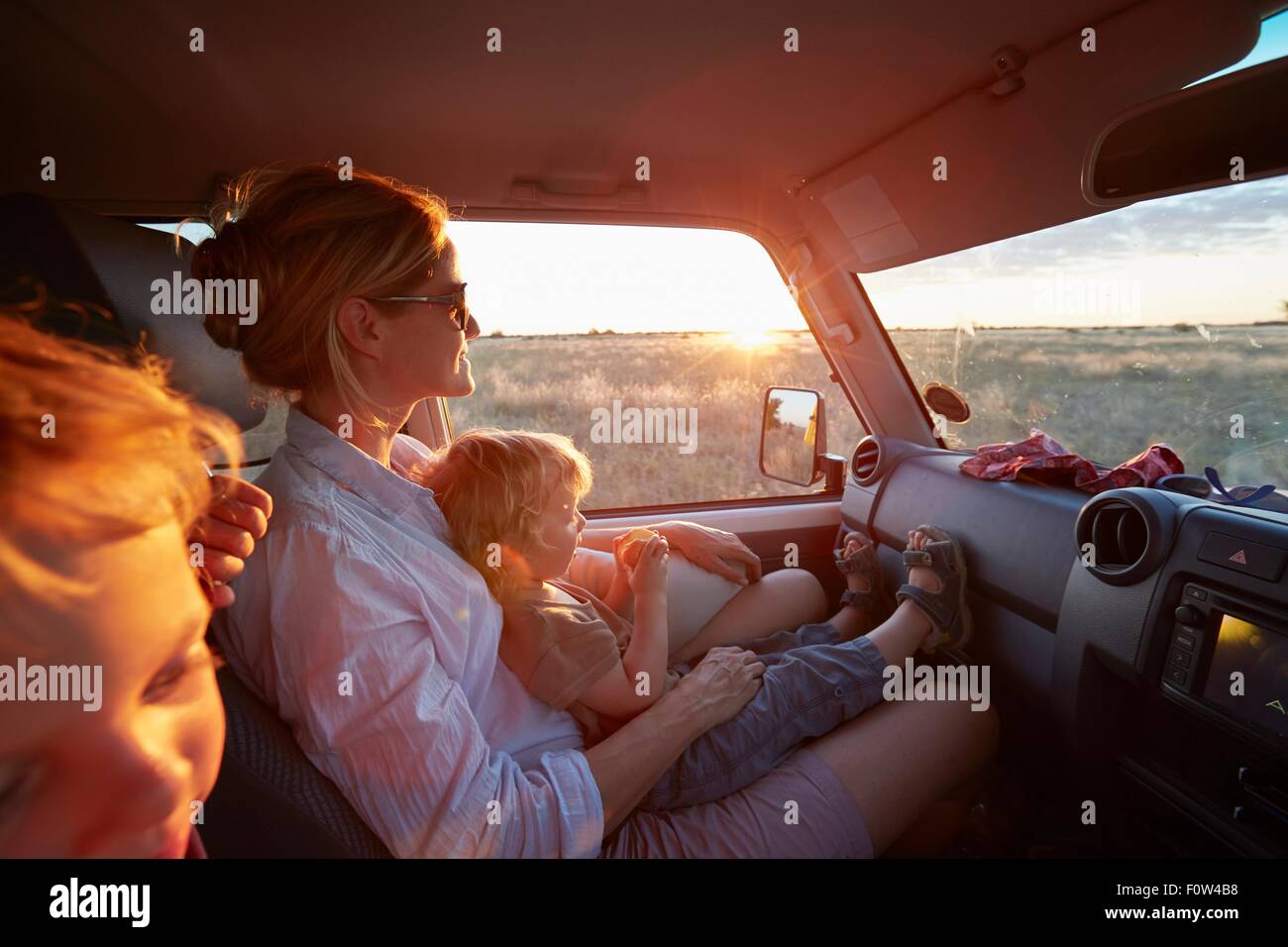 Madre e figli viaggiare nel veicolo, Nxai Pan National Park, Deserto Kalahari, Africa Foto Stock