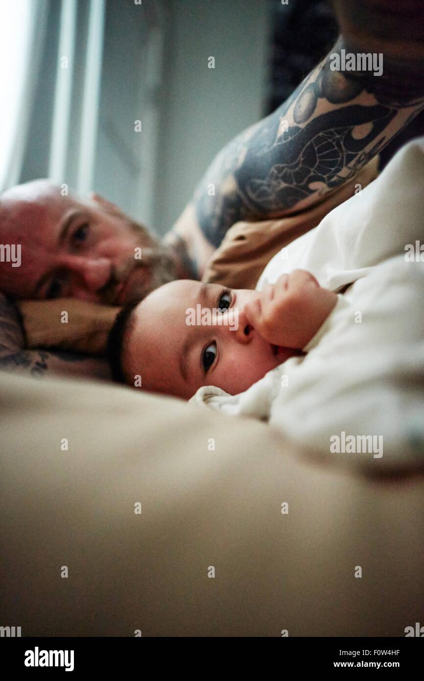 Padre e figlio sdraiato sul letto Foto Stock