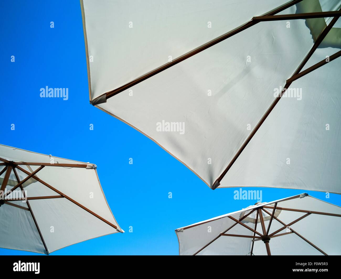 Basso angolo vista di ombrelloni e cielo blu Foto Stock