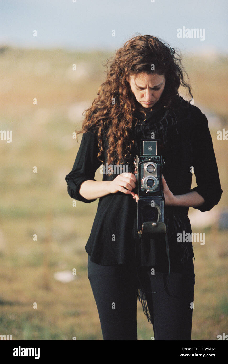 Una donna di scattare una foto con una vecchia fotocamera di medio formato. Foto Stock