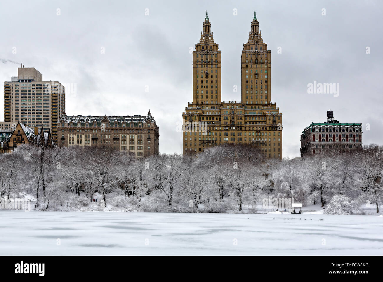 Il San Remo torri in uptown di Manhattan con il congelato e coperto di neve nel lago di Central Park a New York City. Foto Stock