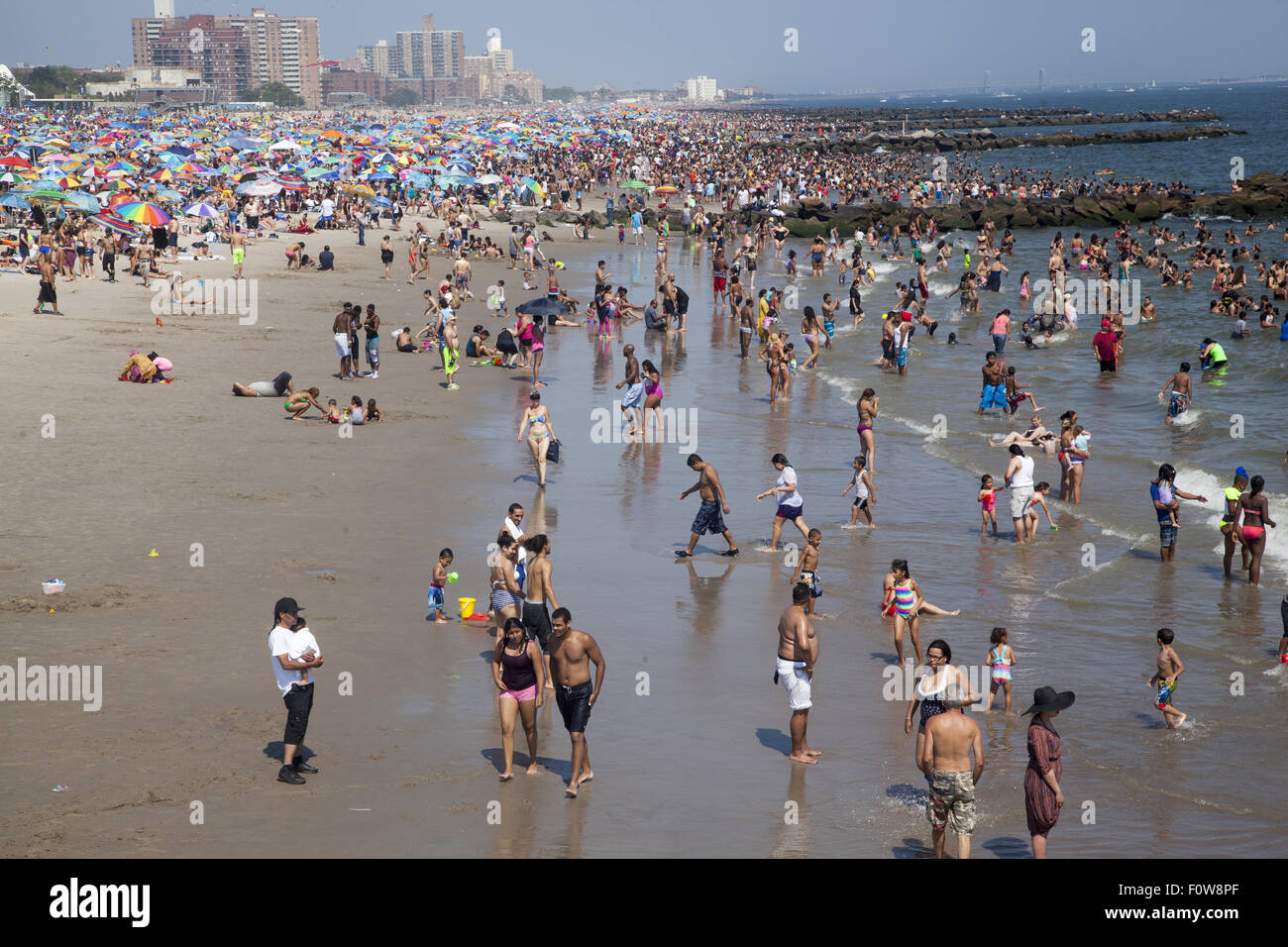 Migliaia di persone per godersi la spiaggia e acqua lungo l'Oceano Atlantico a Coney Island, Brooklyn, New York. Foto Stock