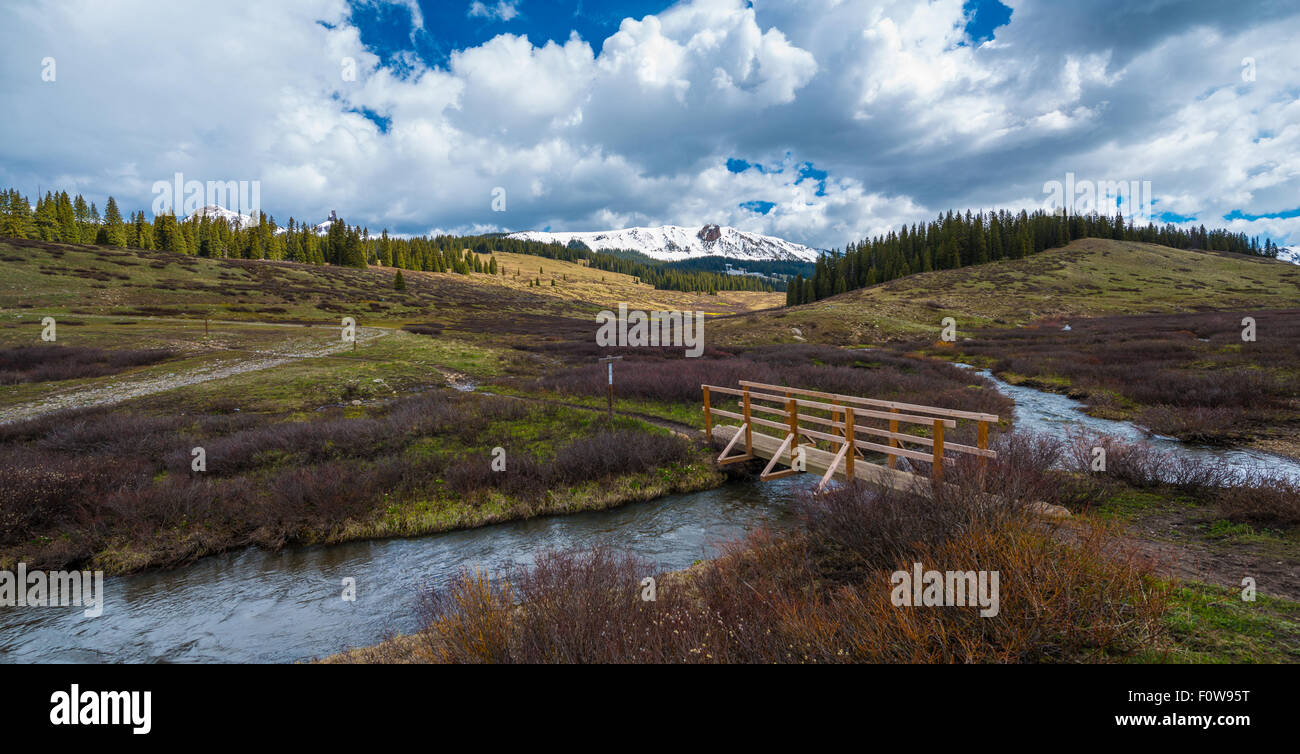 Creek e un ponte pedonale, Colorado Montagne Rocciose paesaggio Foto Stock