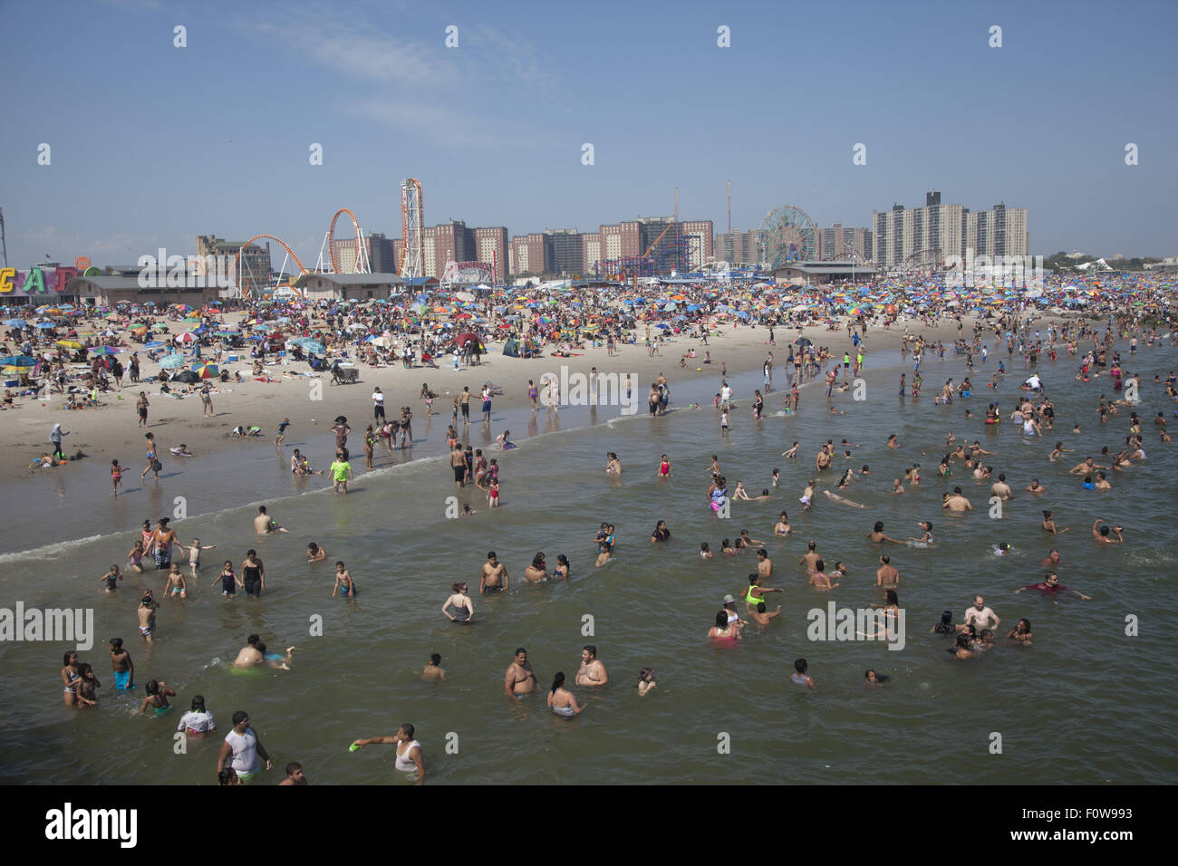 Migliaia di persone per godersi la spiaggia e acqua lungo l'Oceano Atlantico a Coney Island, Brooklyn, New York. Foto Stock