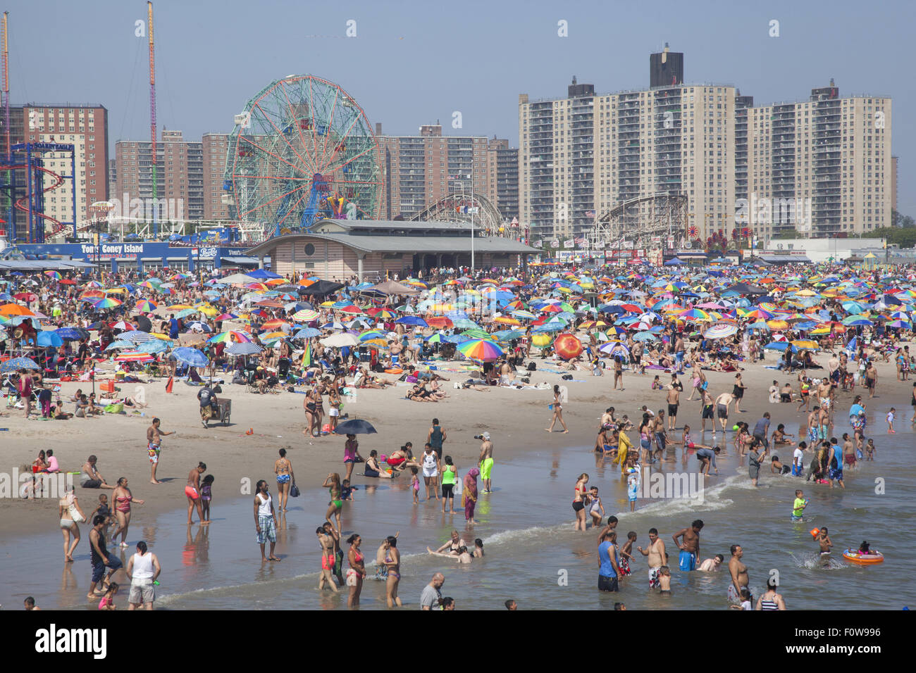 Migliaia di persone per godersi la spiaggia e acqua lungo l'Oceano Atlantico a Coney Island, Brooklyn, New York. Foto Stock