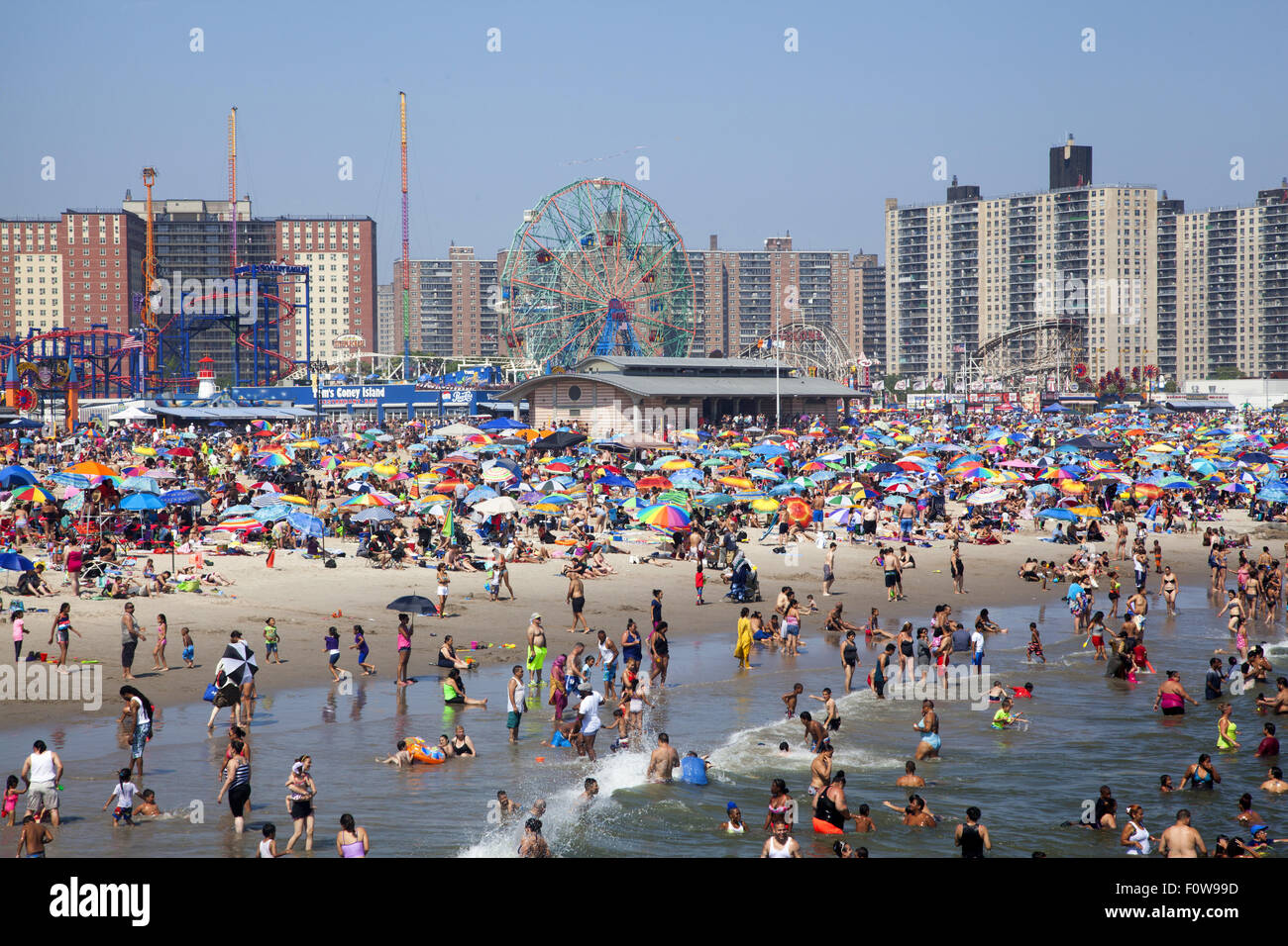Migliaia di persone per godersi la spiaggia e acqua lungo l'Oceano Atlantico a Coney Island, Brooklyn, New York. Foto Stock