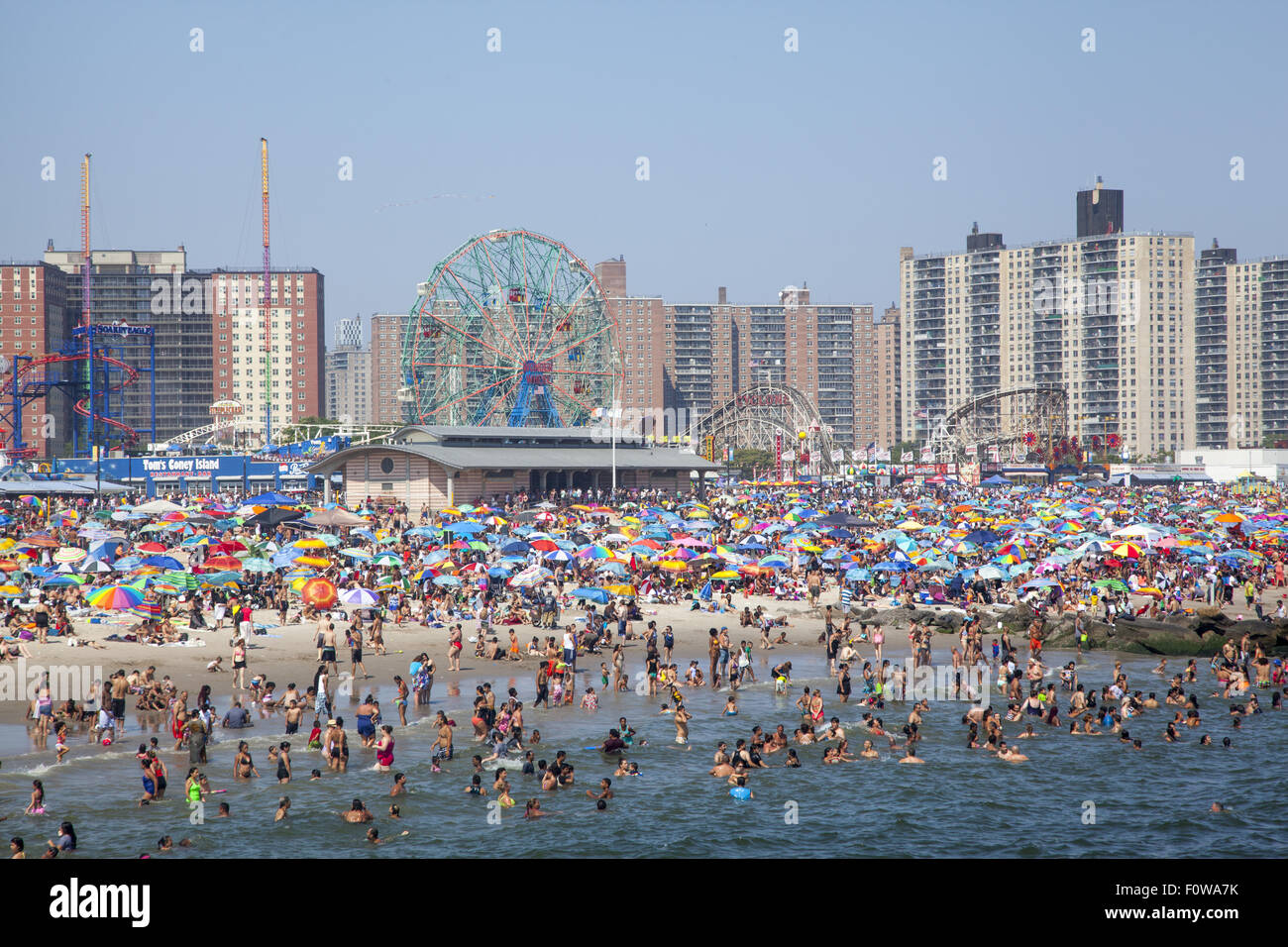 Migliaia di persone per godersi la spiaggia e acqua lungo l'Oceano Atlantico a Coney Island, Brooklyn, New York. Foto Stock