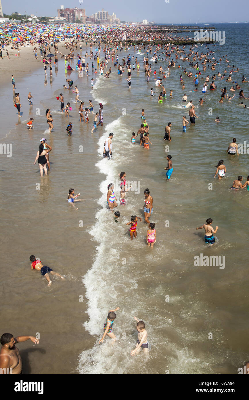 Migliaia di persone per godersi la spiaggia e acqua lungo l'Oceano Atlantico a Coney Island, Brooklyn, New York. Foto Stock