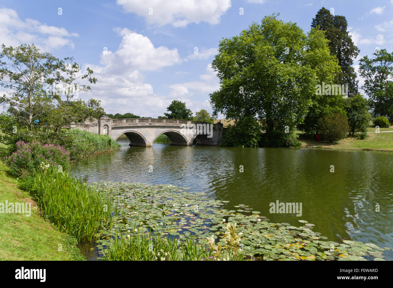 A tre archi di ponte di pietra andando oltre il lago a Compton Verney House, Warwickshire, Regno Unito Foto Stock